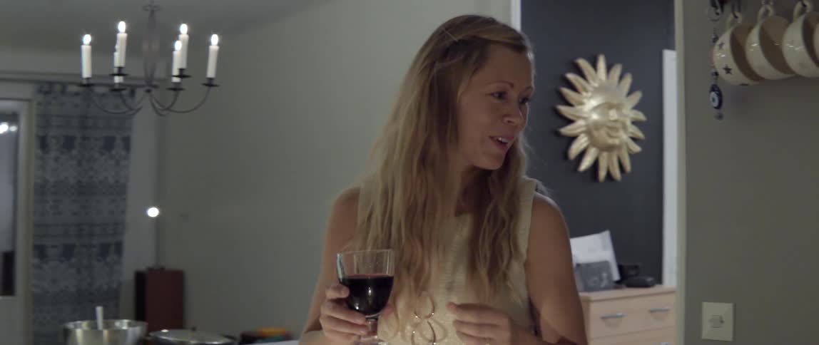 Woman holding wine glass speaking with warm conversational social atmosphere