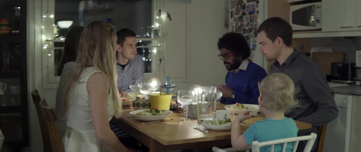 People sitting around table enjoying a meal together with warm communal vibe