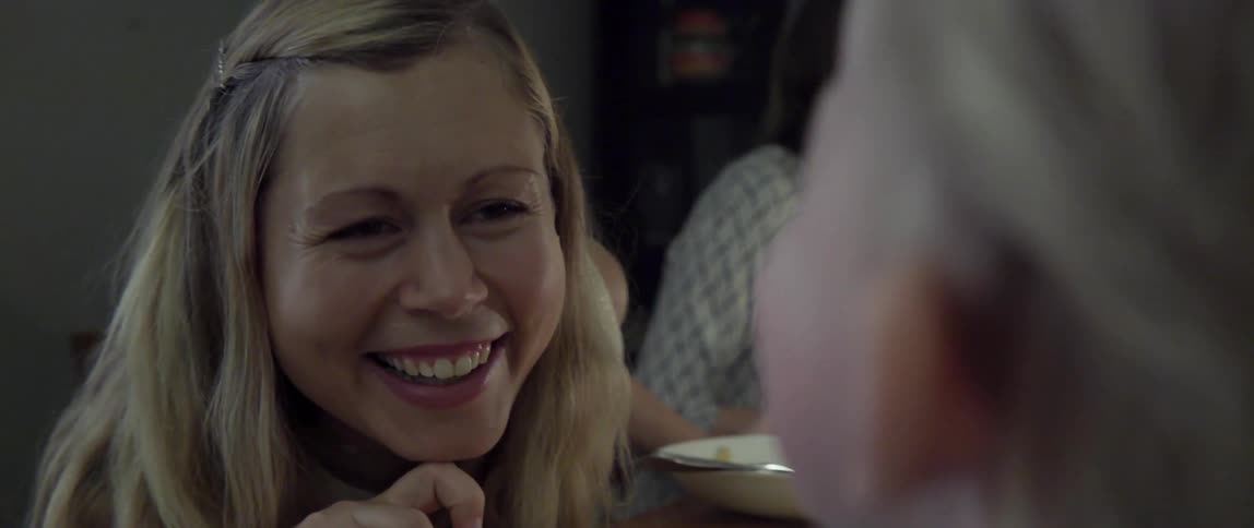 Woman talking and smiling at a toddler at dinner table