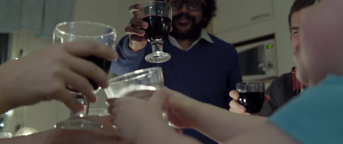 Young adults celebrating together with a cheerful toast during a communal family style dinner.