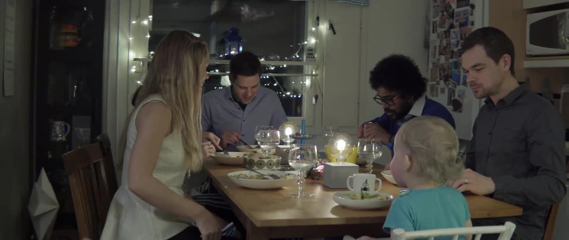Group of friends eating a meal together at night with lively energy