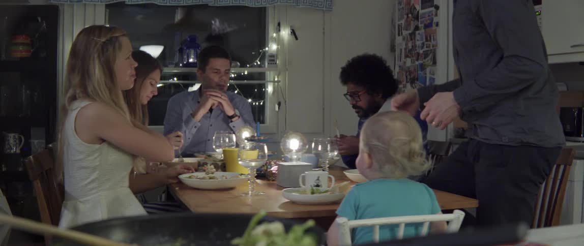Group of people having dinner together around table with lively warm energy
