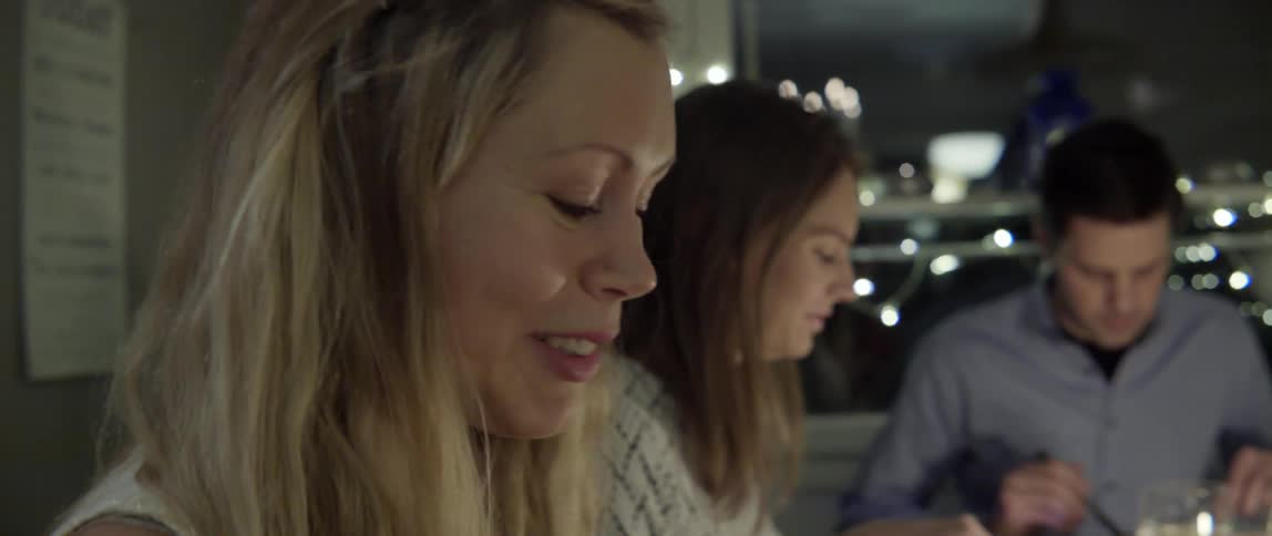People Sitting at a Table Eating and Talking Together With Warm Laughter and Connection