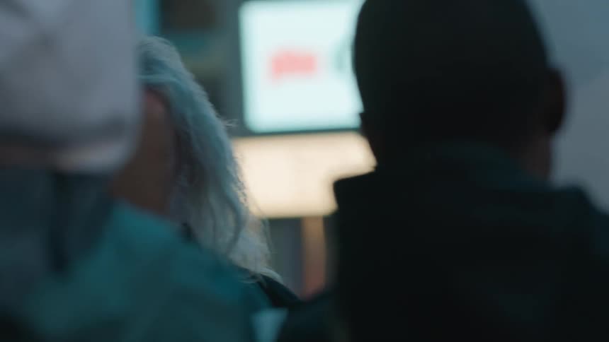 People standing near businesses with rally signs smile at each other