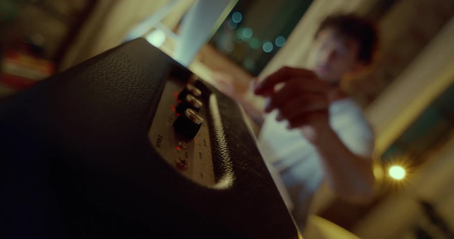 Man working on computer reaches over to adjust setting on knob