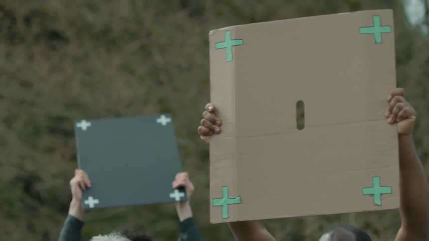 People hold up signs at a rally