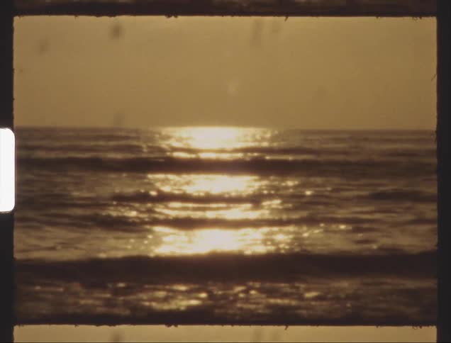 The ocean water glitters in the sunlight on the beach