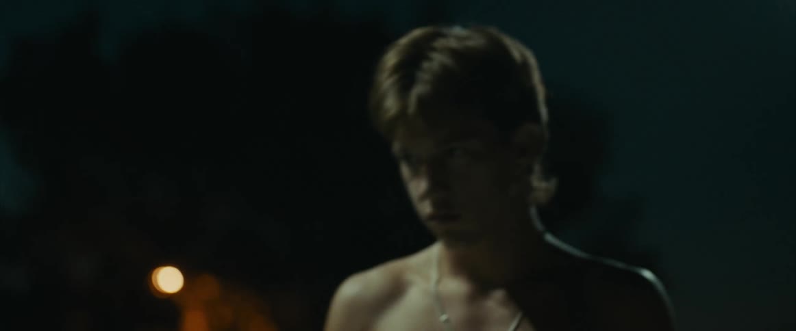 Angry Shirtless Teenage boy outside stepping back at night