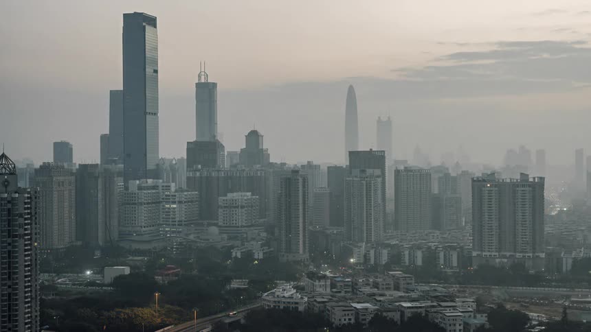 City skyline with illuminated high rise buildings and vehicles driving on highways