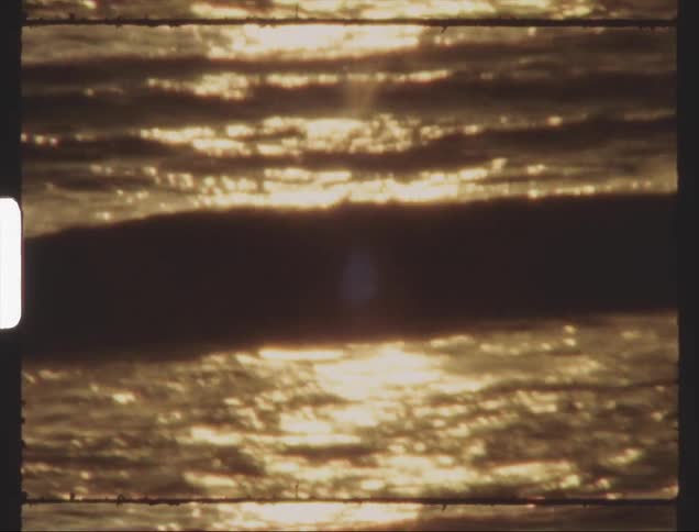 The ocean water glitters in the sunlight on the beach