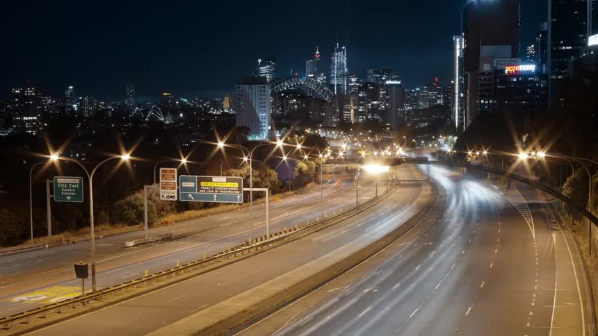 Vehicles drives on divided highway at night in the city