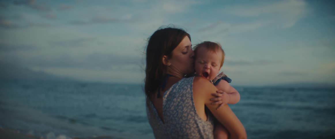 A mother and baby outdoors near the beach