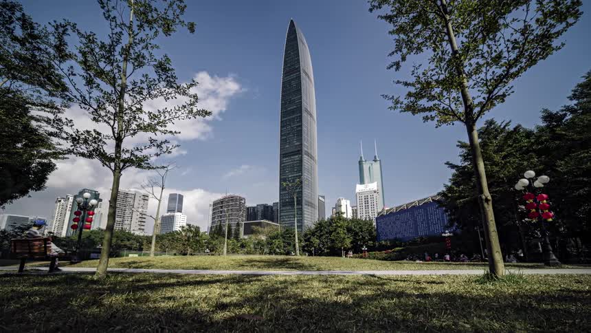 People walk through a park that runs alongside downtown