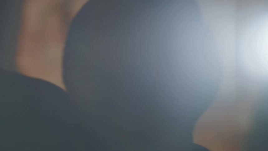A person is moving in the dark near a lit up sign