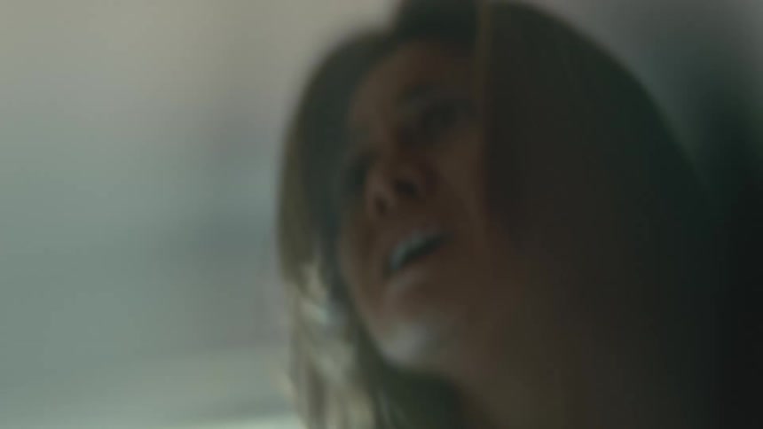 A woman yells and screams out while standing indoors
