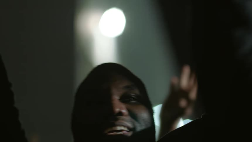 Happy black man shouting with a protesting crowd in the middle of the city at night