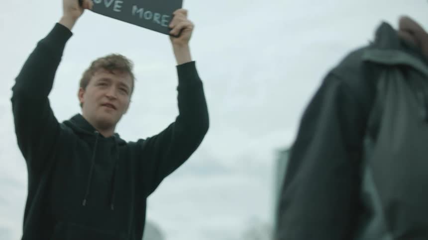 A protester yells and waves a sign