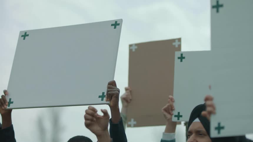 People are waving signs at a rally