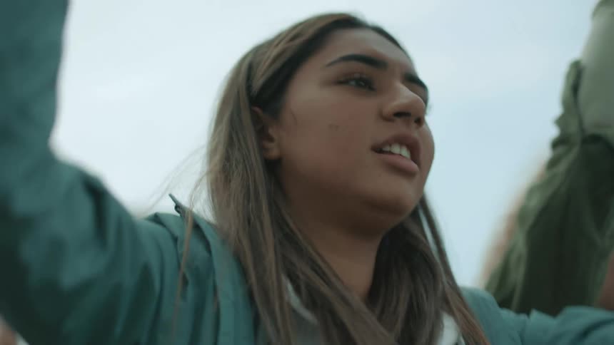 A teenager yells chants and waves a sign during a protest