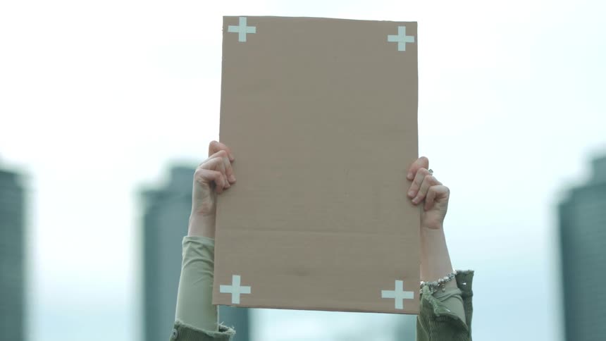 A woman raises her sign on the field