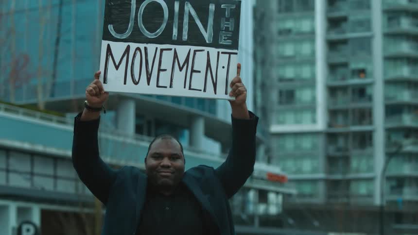A man is protesting downtown in a city