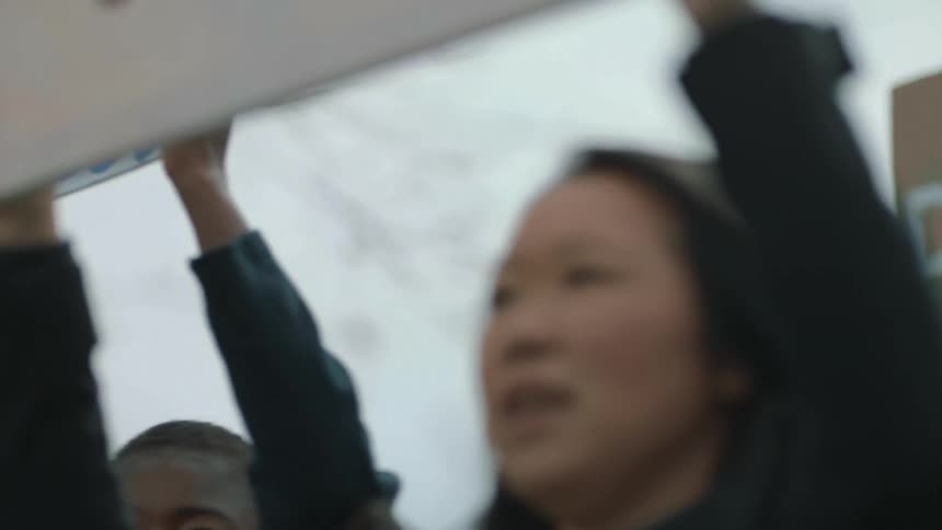 A group of people are protesting outdoors during the day time