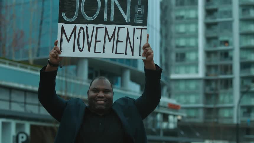A man protesting lifting a sign