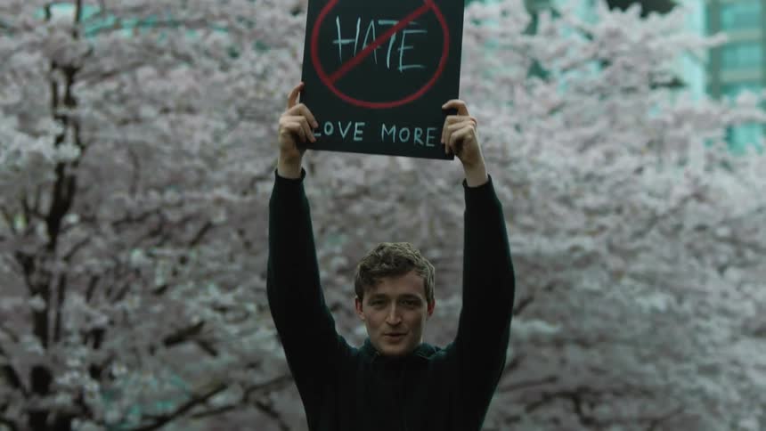 A man raises a sign above his head