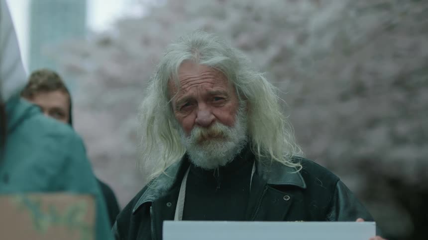 A man standing outdoors with a sign