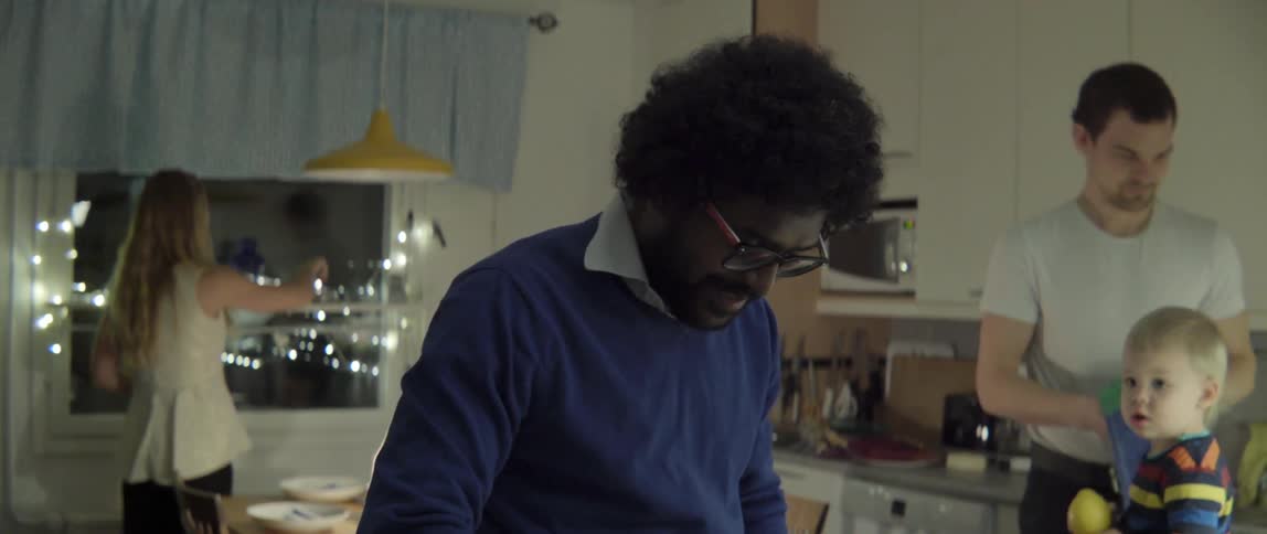 A group of people work in a kitchen in an apartment at night