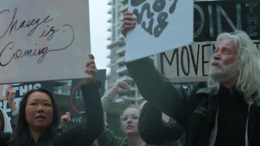 A group of people march together with signs in a protest