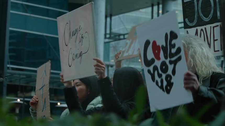 A group of people are protesting outdoors in the spring time