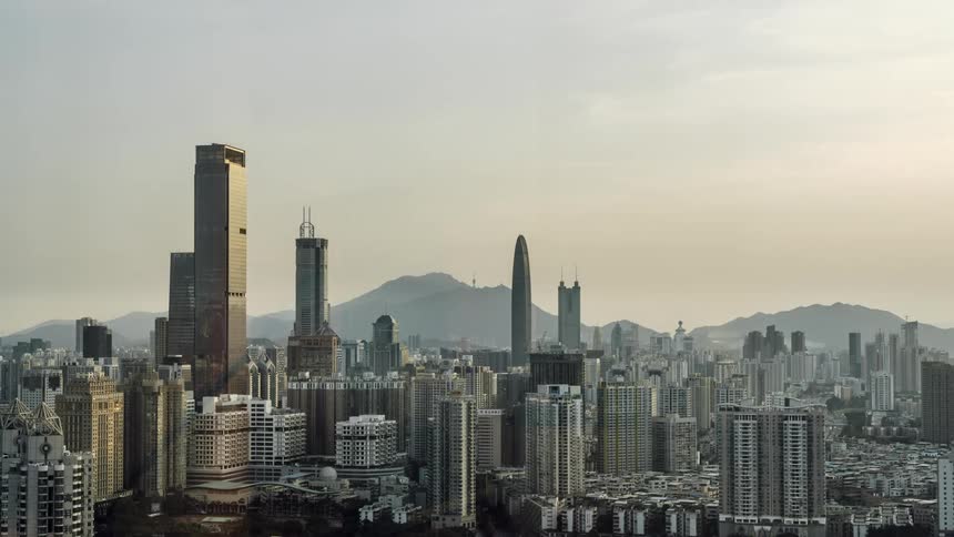 City skyline with high rise buildings and distant mountains