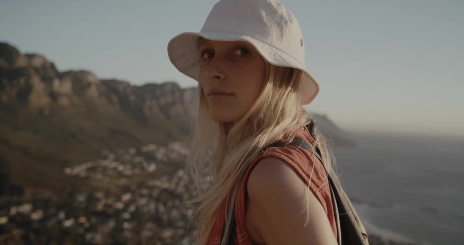 A woman is on the mountain look at the ocean