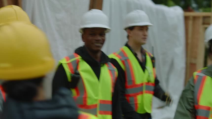 A female construction worker is talking to the crew on the site