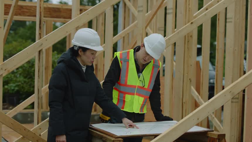 A woman manager discusses building plans on a construction site