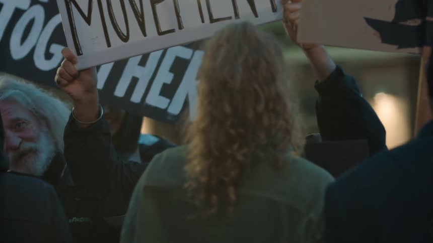 Protesters talk and carry signs