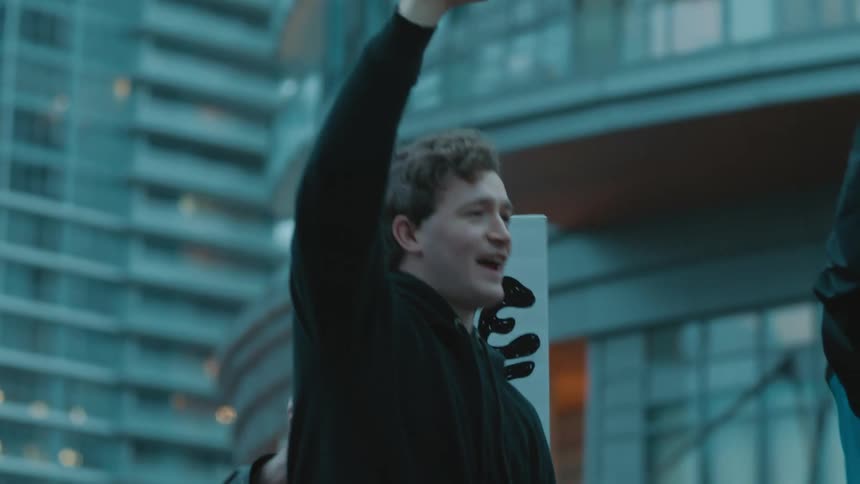 A group of people wave signs and chant as they march downtown
