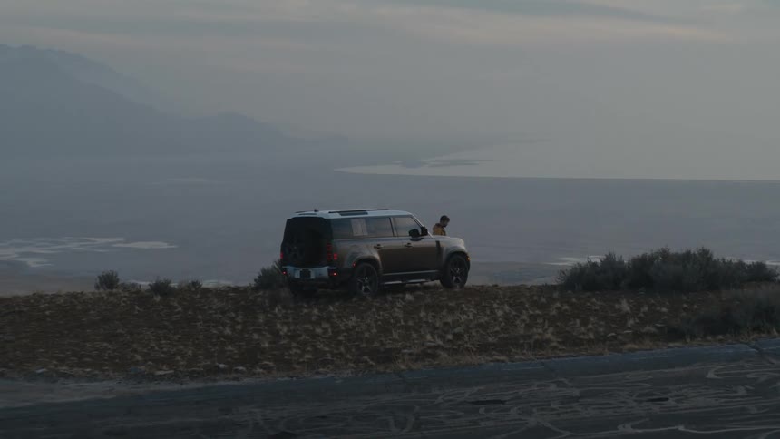 A view of a person next to a car at the beach
