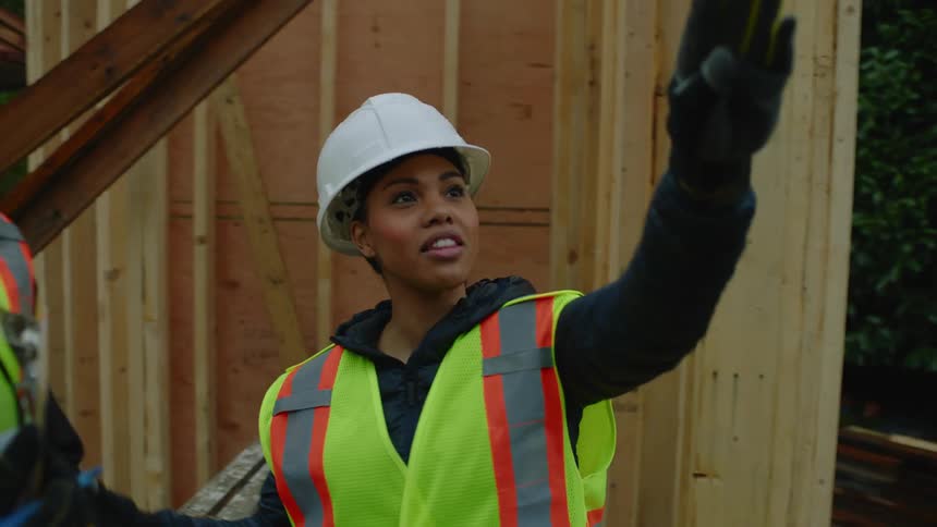 A black female construction manager smiles as she explains what needs to be done