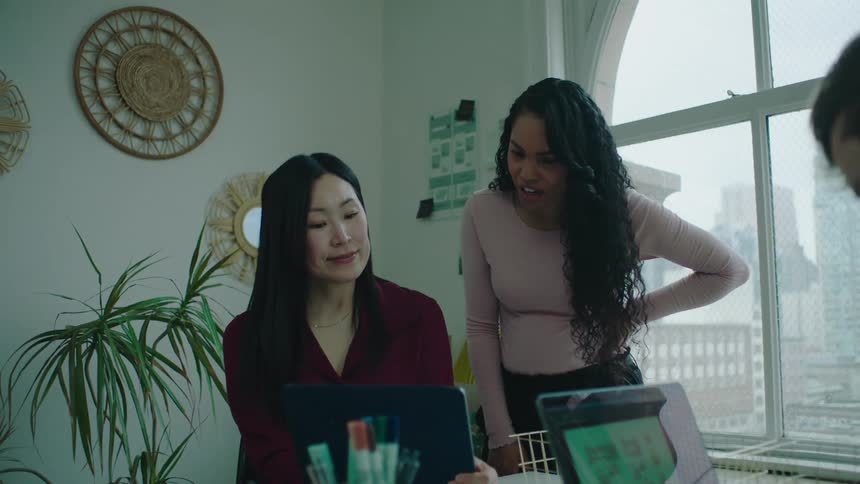 Coworkers talk and use computers