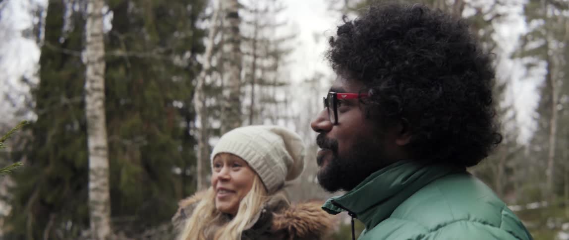 Man and woman smiling together in forest with festive holiday joy