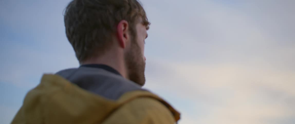 White man wearing a yellow coat taking pictures with his digital camera outdoors