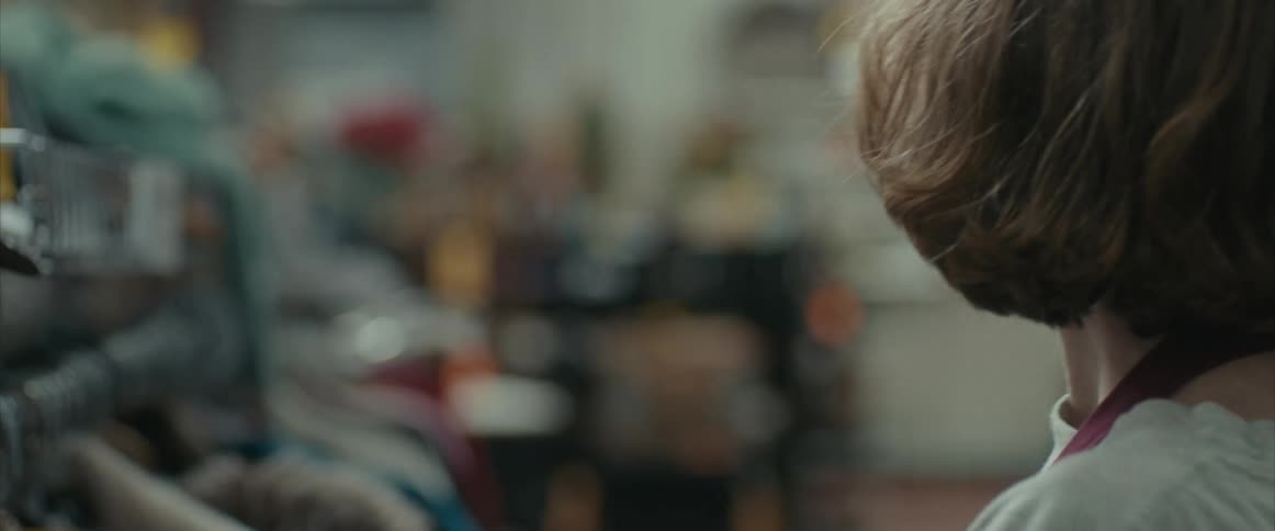 A teenager is shopping and looking at clothing when another one runs up and stops
