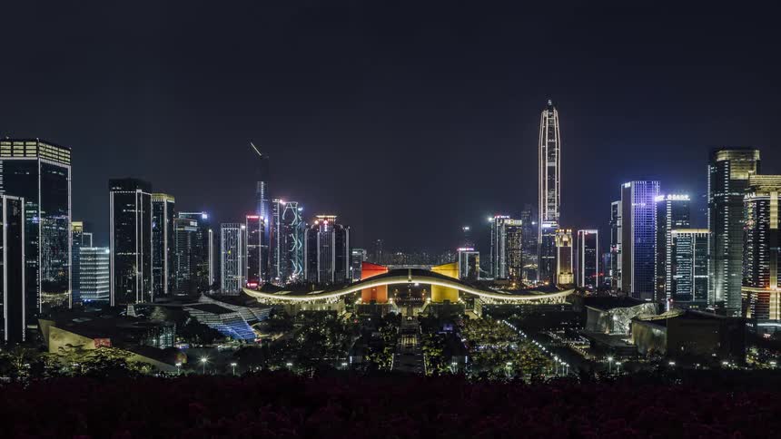 Time lapse of lit up sky scrapers in a city skyline at night