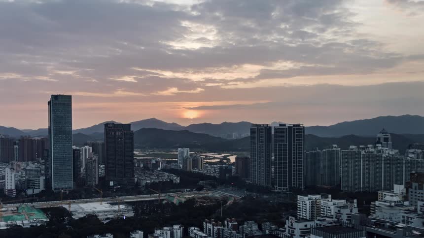 A time lapse of high rise office buildings in a city with cars driving on the streets