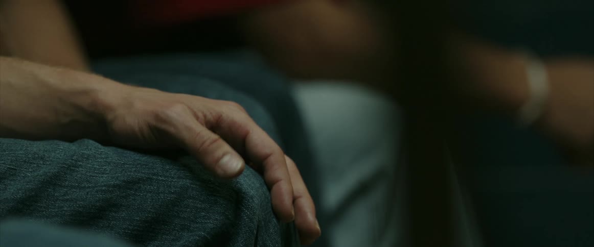 A man anxiously taps his hand on his leg over and over while sitting in a waiting room