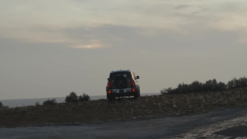 A man stands by his jeep admiring the scenery