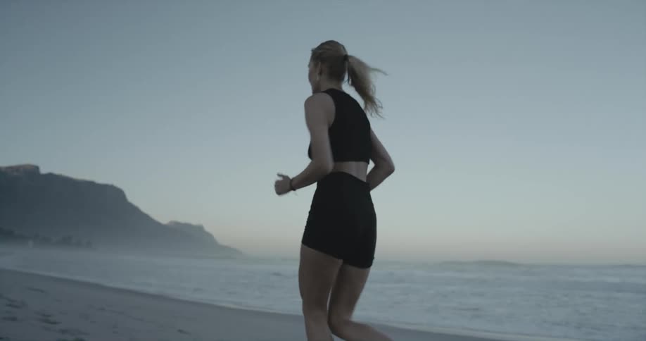 A woman is jogging on the beach
