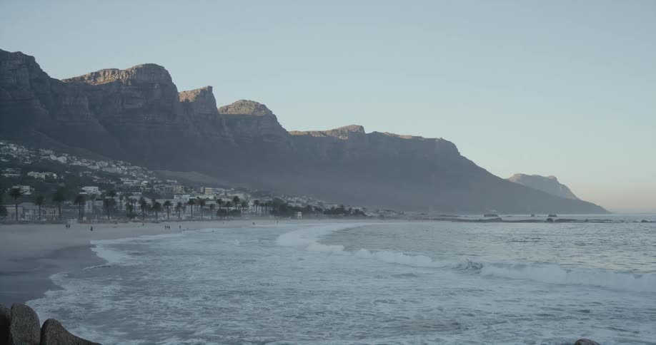 A beach on the outskirts of a small town on a hillside during the day
